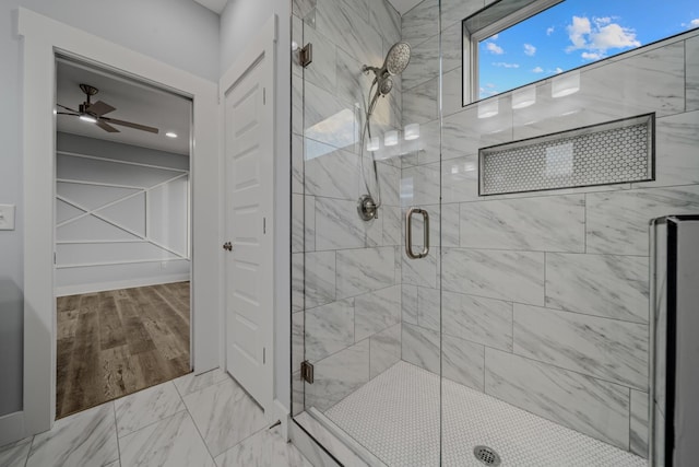 bathroom featuring marble finish floor, ceiling fan, and a shower stall