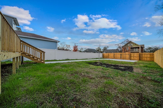 view of yard featuring a fenced backyard and stairway