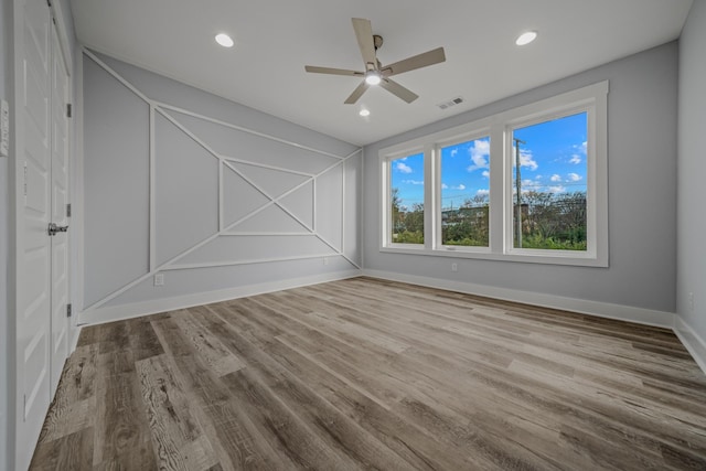 spare room featuring recessed lighting, visible vents, baseboards, and wood finished floors