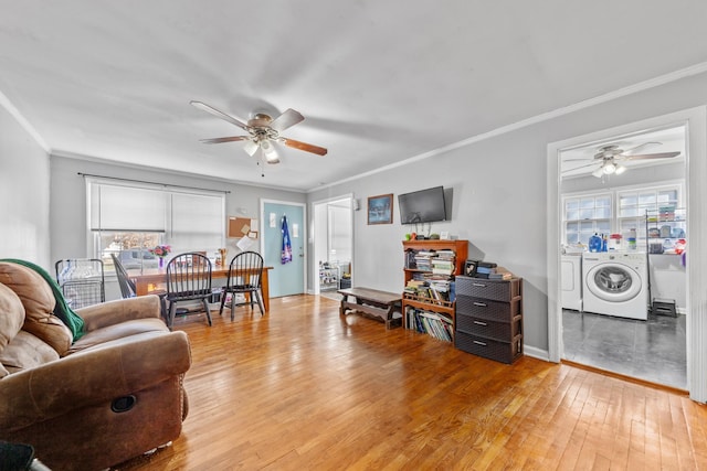 living area with washer and clothes dryer, ornamental molding, ceiling fan, wood finished floors, and baseboards