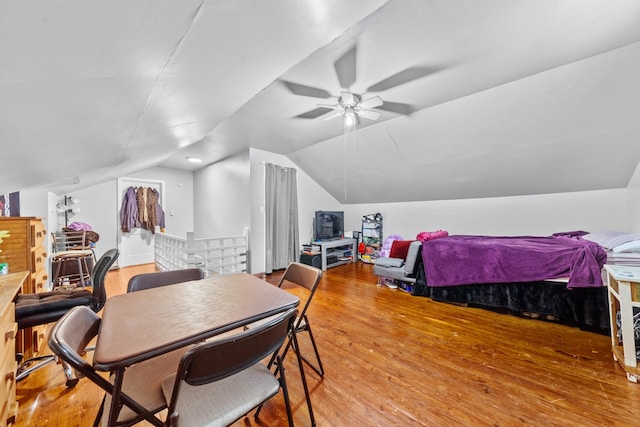 dining room with visible vents, a ceiling fan, vaulted ceiling, and wood finished floors