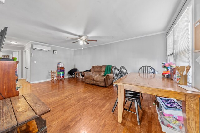 living room with crown molding, ceiling fan, wood finished floors, a wall mounted air conditioner, and baseboards