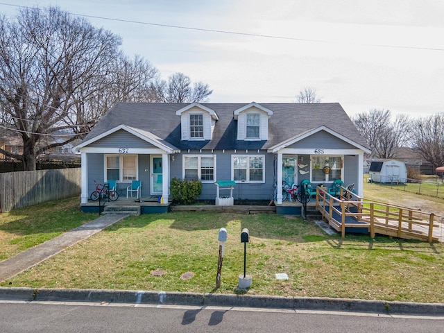 view of front of home featuring covered porch, a front yard, and fence