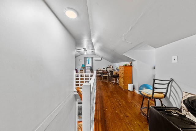 interior space featuring vaulted ceiling, an upstairs landing, and wood finished floors