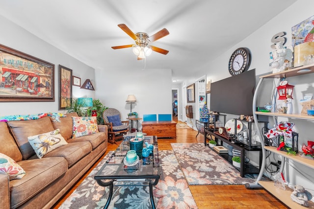 living area with wood finished floors and a ceiling fan