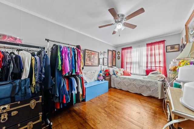 bedroom featuring ornamental molding, a ceiling fan, and wood finished floors