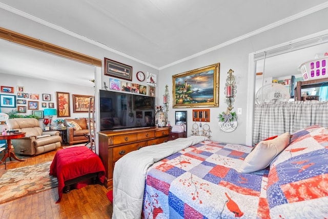 bedroom with crown molding and wood finished floors