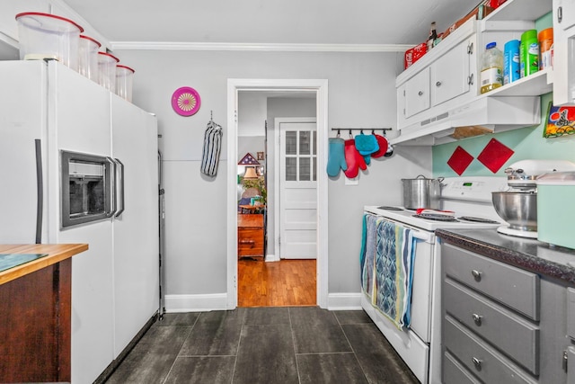 kitchen with white appliances, dark countertops, gray cabinetry, under cabinet range hood, and white cabinetry