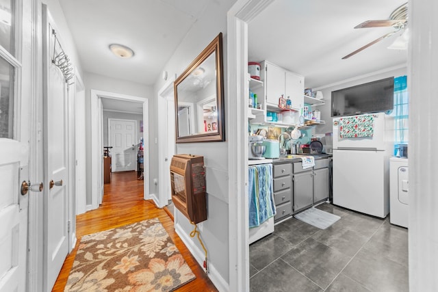 washroom with heating unit, washer / clothes dryer, ceiling fan, laundry area, and baseboards