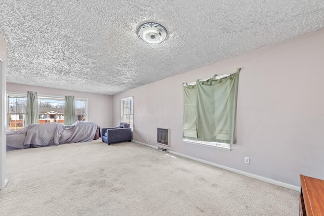 bedroom featuring baseboards, carpet flooring, a textured ceiling, and heating unit