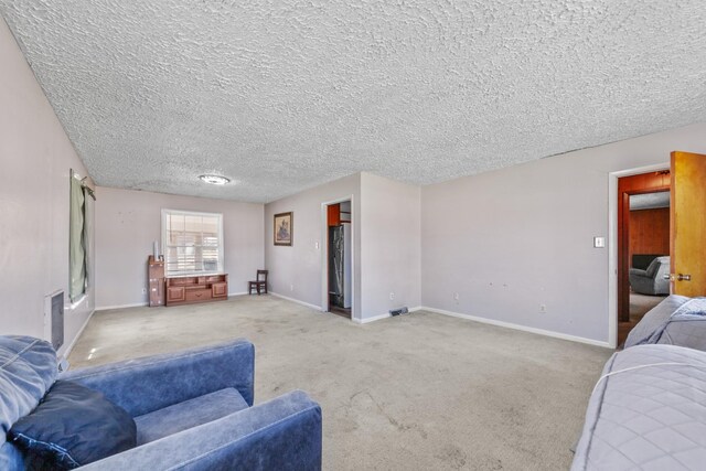 living room with baseboards, a textured ceiling, visible vents, and light colored carpet