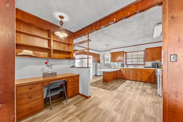 interior space featuring water heater, light wood finished floors, a textured ceiling, and built in study area