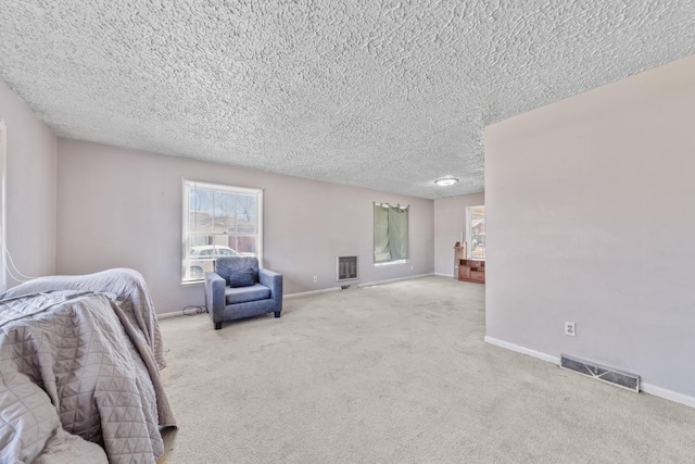 living area with baseboards, a textured ceiling, visible vents, and light colored carpet