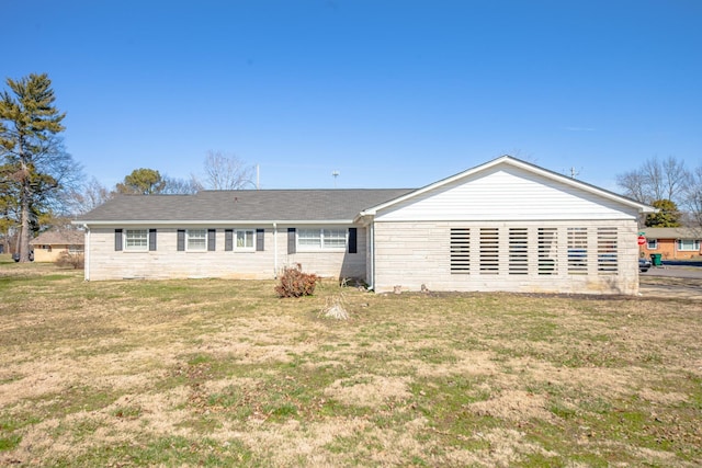 rear view of property featuring a lawn