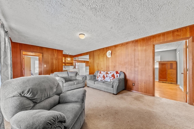 carpeted living room featuring a textured ceiling and wooden walls