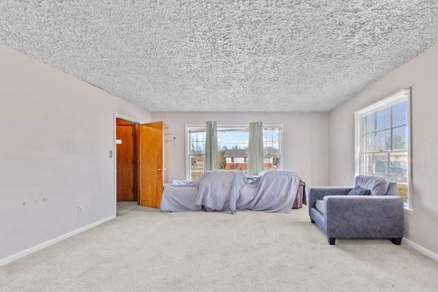 living area featuring a textured ceiling, carpet floors, and baseboards