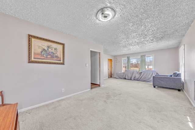 bedroom with light colored carpet, a textured ceiling, and baseboards