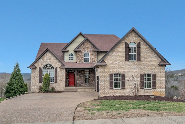 view of front of property with brick siding and a shingled roof