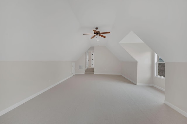 bonus room featuring lofted ceiling, visible vents, baseboards, and light colored carpet