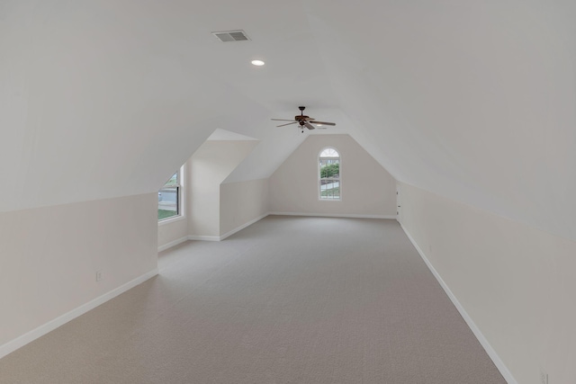 additional living space with lofted ceiling, visible vents, light carpet, and baseboards