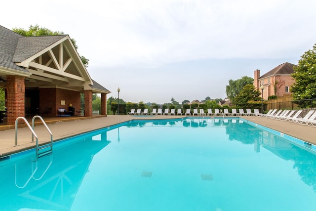 community pool featuring fence and a patio