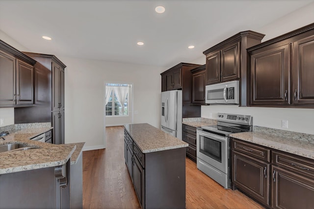 kitchen with appliances with stainless steel finishes, recessed lighting, light wood-style flooring, and dark brown cabinetry