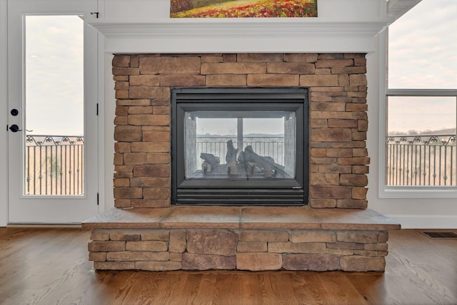 interior details with a fireplace, wood finished floors, and visible vents