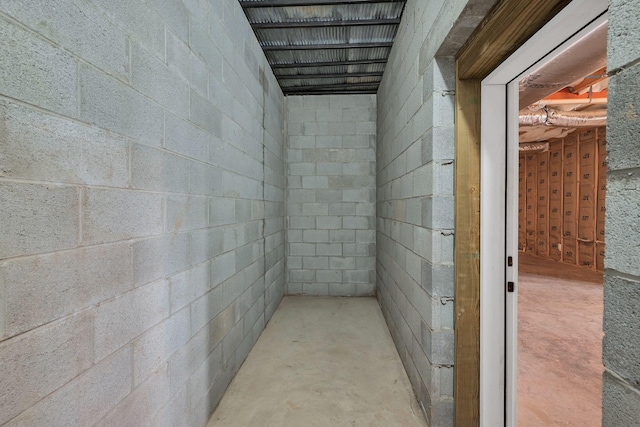 interior space featuring concrete block wall and unfinished concrete floors