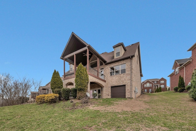 rear view of house featuring brick siding, a lawn, an attached garage, and a balcony