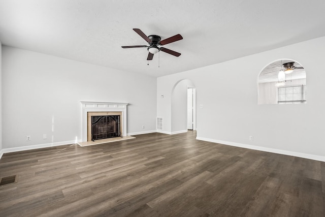 unfurnished living room featuring visible vents, dark wood-style flooring, and a high end fireplace