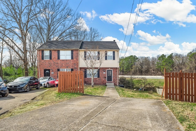 view of front of home with brick siding and fence