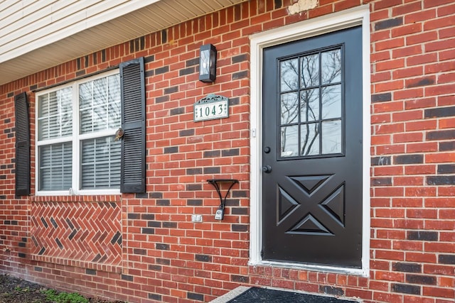 doorway to property with brick siding