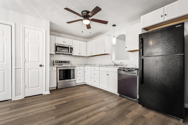 kitchen with a ceiling fan, dark wood-type flooring, black appliances, white cabinetry, and pendant lighting