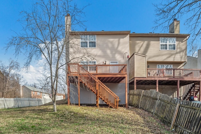 back of house with a fenced backyard, stairs, a deck, and a lawn