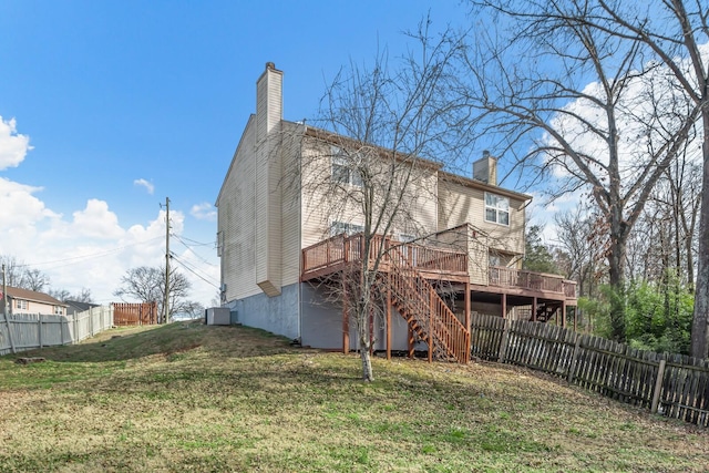 rear view of property featuring a deck, a fenced backyard, stairs, a yard, and a chimney