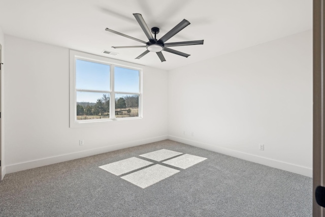 carpeted spare room featuring baseboards, visible vents, and a ceiling fan