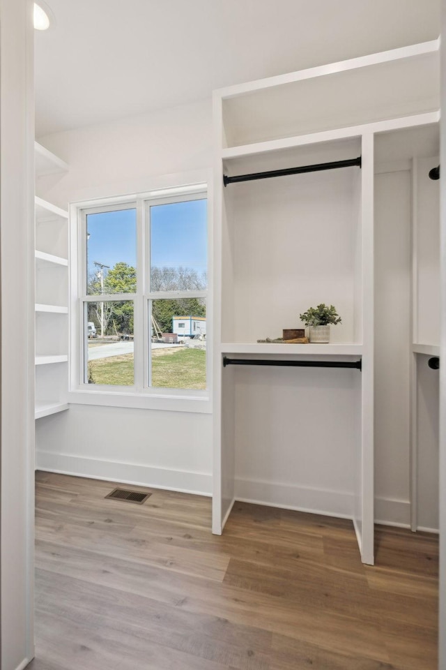 spacious closet featuring wood finished floors and visible vents