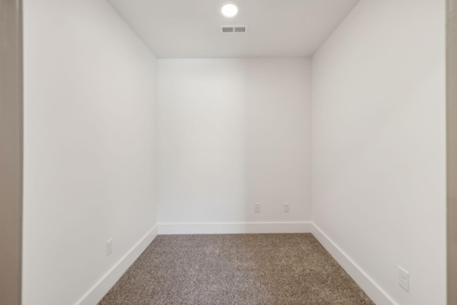 carpeted empty room featuring baseboards and visible vents