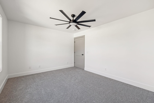 carpeted empty room with ceiling fan and baseboards