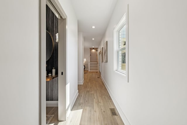 corridor featuring recessed lighting, visible vents, baseboards, stairs, and light wood-type flooring