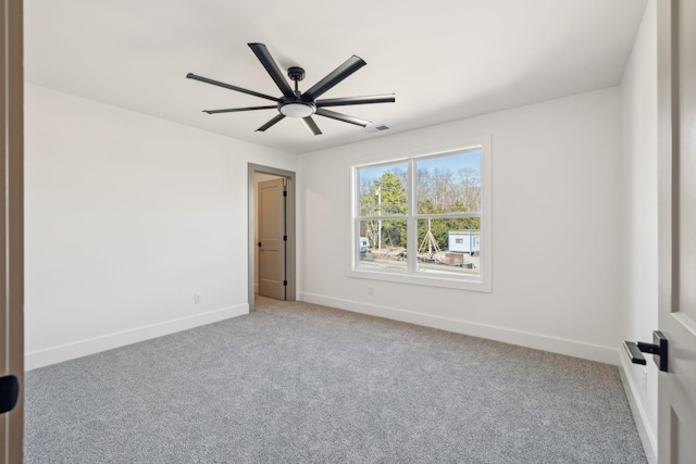 carpeted empty room featuring visible vents, ceiling fan, and baseboards