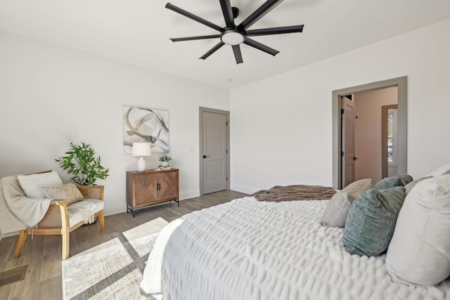 bedroom featuring ceiling fan, baseboards, and wood finished floors