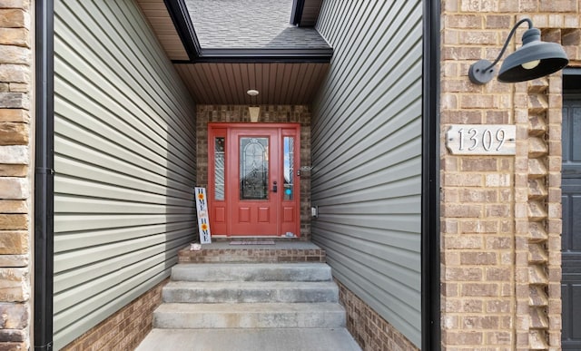 view of exterior entry with brick siding