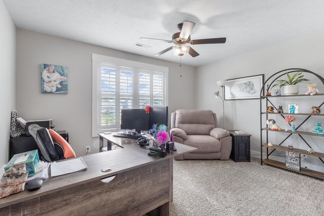 carpeted office with a textured ceiling, visible vents, and a ceiling fan