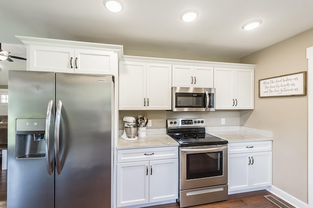 kitchen featuring visible vents, white cabinets, dark wood finished floors, light stone countertops, and stainless steel appliances