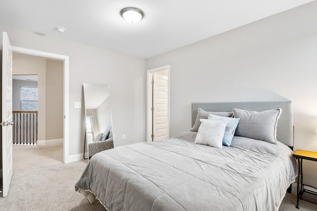 bedroom with baseboards and light colored carpet