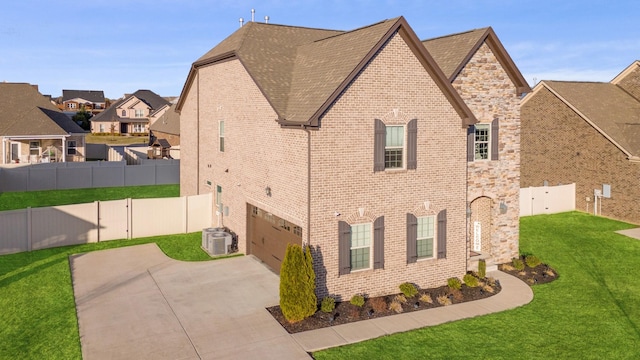 view of home's exterior featuring brick siding, fence, a yard, concrete driveway, and stone siding