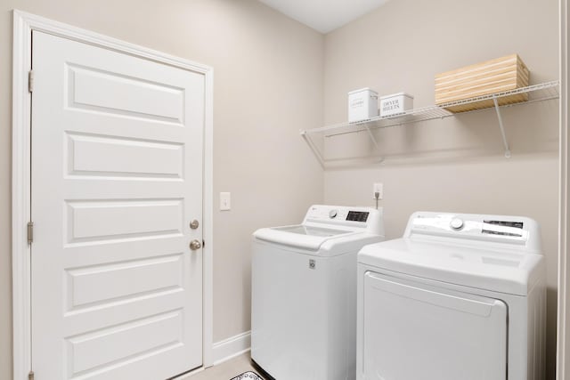 clothes washing area with laundry area, independent washer and dryer, and baseboards