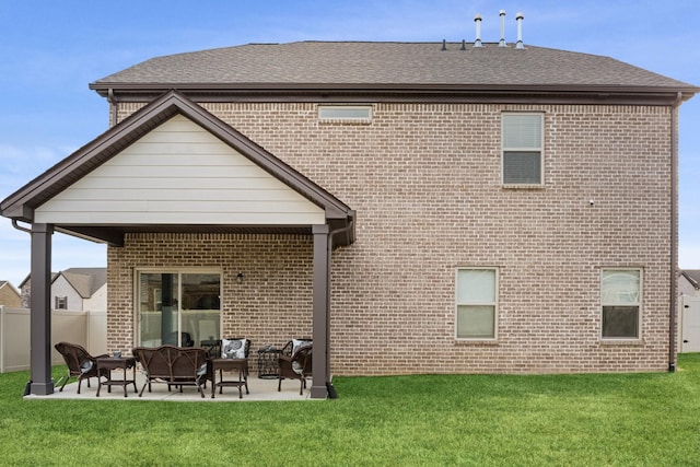 back of house with a patio, brick siding, a lawn, and an outdoor living space