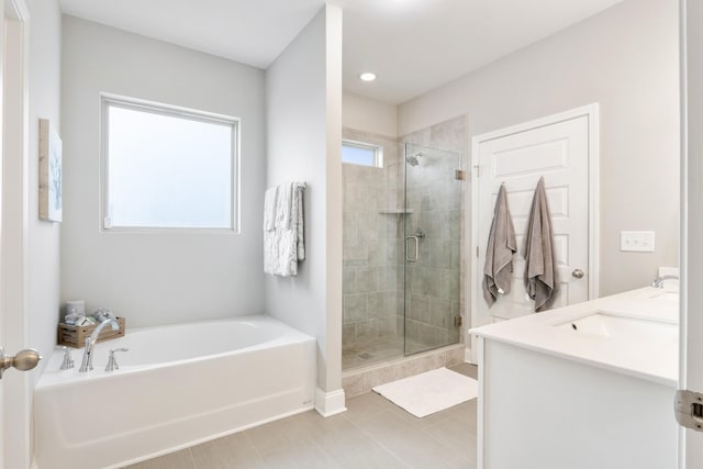 full bath with a wealth of natural light, a shower stall, a bath, and double vanity